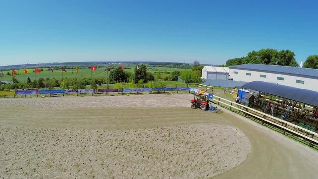 Tractor smooths sand on equestrian arena Sozidatel 