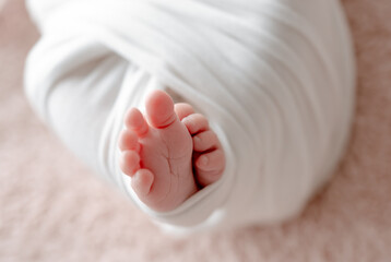 Newborn Baby'S Legs Wrapped In A Blanket Are Shown In Close-Up