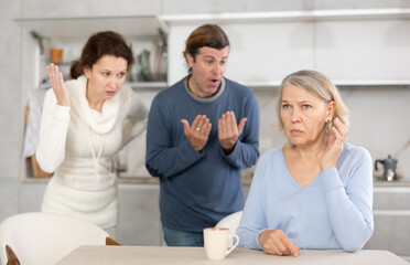 Married couple shouts at elderly mother. Family conflict between spouses and mother-in-law.