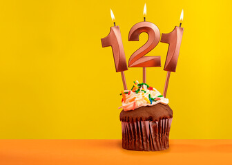 Number 121 birthday candle - Celebration on yellow background
