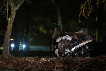 Wrecked car upside down after accident at night