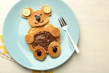 Creative serving for kids. Plate with cute bear made of pancakes, blueberries, bananas and...