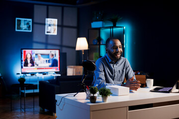 Influencer in home studio using professional microphone to record live broadcast for online streaming platforms, talking with fans. African american online star hosts q and a session with viewers