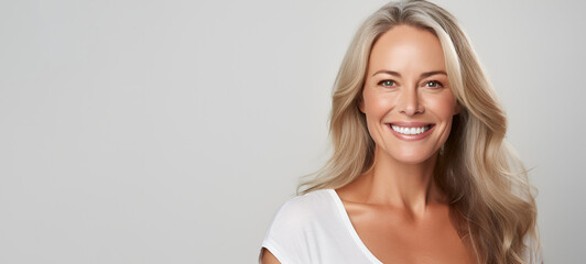 Beautiful middle-aged woman on a gray background.