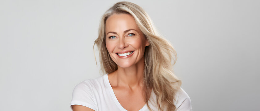 Beautiful middle-aged woman on a gray background.