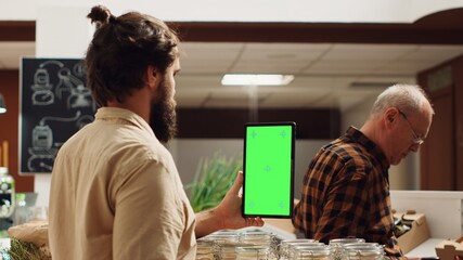 Man using isolated screen smartphone in zero waste supermarket to check ingredients for healthy...