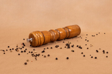 Old wooden pepper mill on a brown background	
