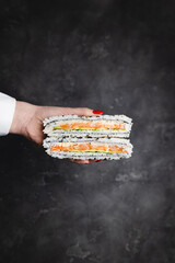 Delicious sandwich roll, sushi sandwich with salmon, rice and avocado. Asian food, restaurant, fast food.