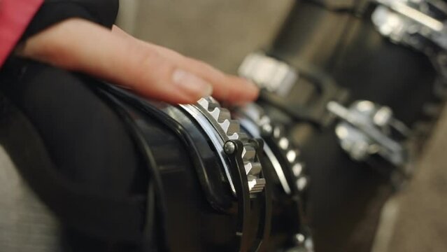 Close up person locking buckles or latches on ski boots before going out. Preparation for downhill skiing in snow mountain or ski resort in winter. Changing room or lockers wearing professional gear