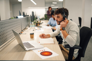 A call center worker is talking on headset with customer.
