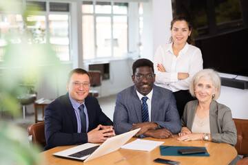 Fototapeta premium Group of different people in business suits pose sitting at table in office..