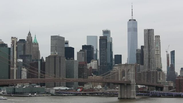 nyc skyline view with water moving on a gray overcast sky day (ferries on the water, view from manhattan bridge, dumbo carousel) downtown footage with one world trade center, brooklyn bridge 