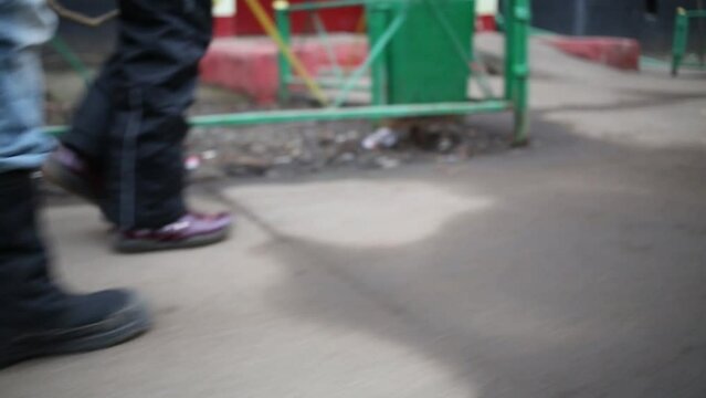 Legs of two children walking down street at spring day