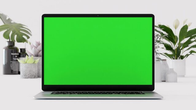 Close up shot of laptop on white background with green screen chroma key, 4k slow motion with decorative indoor plants in the background