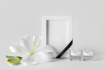 Blank funeral frame, burning candles and beautiful lily flowers on grey background - obrazy, fototapety, plakaty
