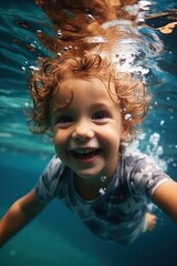 Fototapeta na wymiar Toddler boy swimming underwater