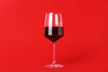 Glass of exquisite wine on red background
