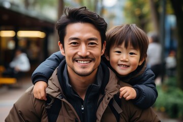 Happy Asian father carrying his son on his back