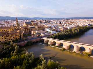 Fototapeta premium Aerial view of Historic centre of Cordoba with antique Roman Bridge over Guadalquivir river and medieval Mosque-Cathedral, Spain