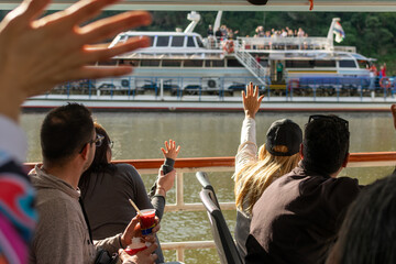 tuor on boat with people greeting other tourists