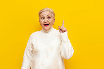 pensive old granny thinking plan and idea on yellow isolated background, elderly pensioner woman pointing finger up and imagining