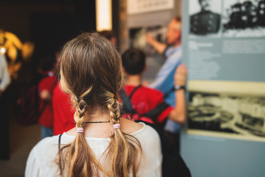 Group of students and school pupils in a science museum exhibition, excursion tour with guide, a docent with a tourist visitors, school field trip, attendees of technical museum exposition gallery