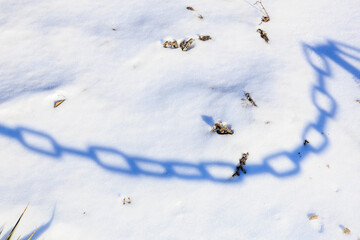 Shadow of a chain on the snow. Background with selective focus and copy space