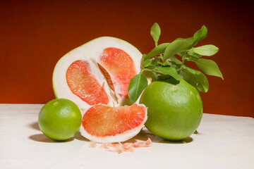 pieces of red Pomelo fruit on an orange background