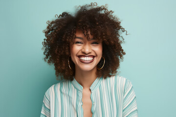 Joyful African American Woman with Cool Afro Hairstyle, Laughing in Studio against Green Wall