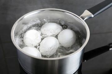 Fototapeta na wymiar Chicken eggs boiling in saucepan on electric stove