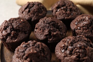 Board with delicious chocolate muffins on table, closeup