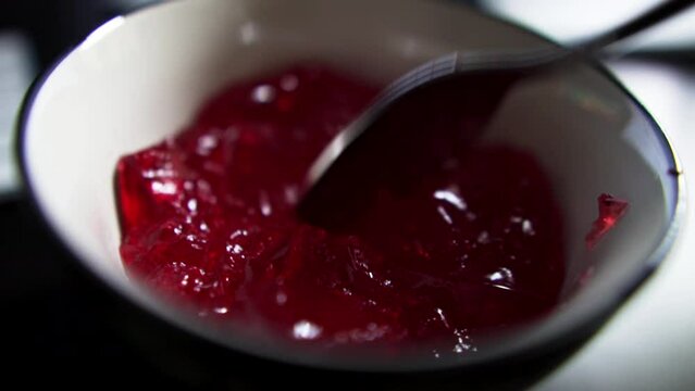 Slow Motion of Red Jelly jiggling in a bowl with a Spoon