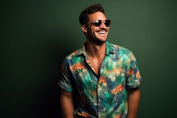 Portrait of a handsome young man with sunglasses, smiling at the camera.