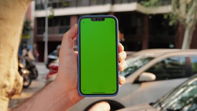 Green Screen chroma key Handheld Smartphone phone with Barcelona transport cars city view, Spain, Travel with phone concept, application mock up. City street in europe.