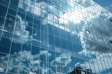Obraz premium Reflection of the sky and clouds in the windows of a high-rise building.