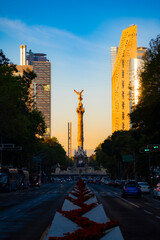 The Angel of Independence statue placed on Promenade of the Reform in Mexico city between tall skyscrapers against morning © Itza