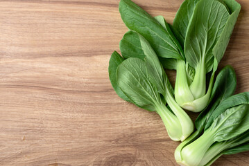 Bok choy or Pak choi (Chinese cabbage) on wooden background, Table top view - obrazy, fototapety, plakaty