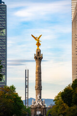 The Angel of Independence statue placed on Promenade of the Reform in Mexico city between tall skyscrapers against midday
