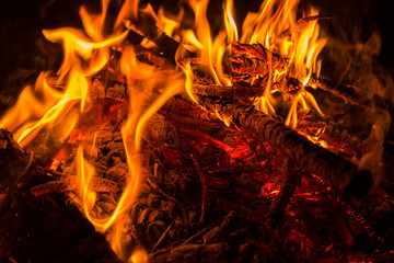 Bonfire with fire flame and red hot coals closeup at night
