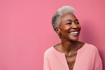 Close up portrait of beautiful smiling mature black woman with pink background in studio. - obrazy, fototapety, plakaty
