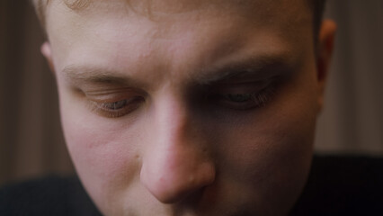 Close-up of young blonde man looking down. Macro extreme close-up	
