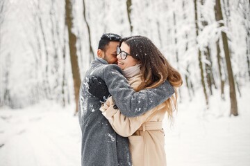 Portrait of a romantic couple spending time together in winter forest