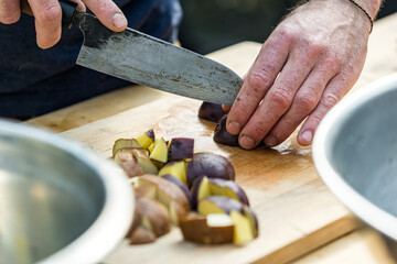 person cutting potatoes