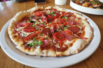 Slice of cheese pizza on a plate on wooden table.
