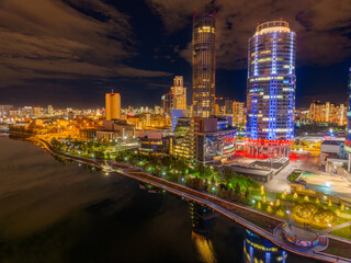 Fototapeta premium Yekaterinburg city and pond aerial panoramic view at summer or early autumn night. Night city in the early autumn or summer.