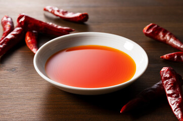 Chili Oil in a ceramic dish placed on a wooden background.