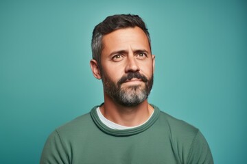 Serious man with beard and mustache looking at camera over blue background
