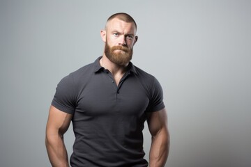 Portrait of a handsome bearded man in black t-shirt on grey background