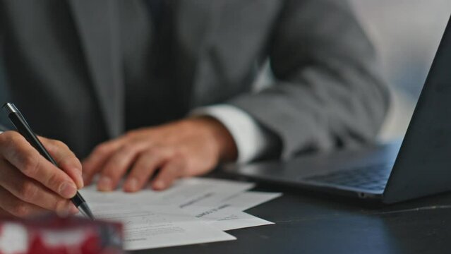 Manager hands writing report with pen closeup. Busy worker browsing computer