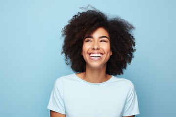 Happy african american woman with afro hairstyle on blue background
